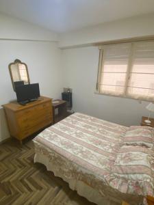 Schlafzimmer mit einem Bett, einer Kommode und einem Spiegel in der Unterkunft Check and Home - Casino - 6 huéspedes frente a la playa y casino in Mar del Plata