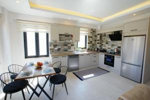 - une cuisine avec une table et des chaises dans la chambre dans l'établissement Villa Ersan 2, à Kaş