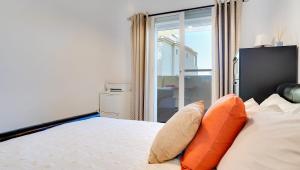 une chambre avec un lit avec des oreillers orange et une fenêtre dans l'établissement Lovely Aldea Beach Apartment, à Manilva 22 autres photos