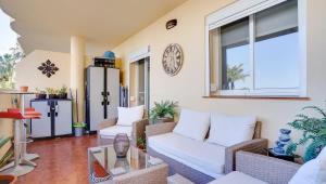 - un salon avec un canapé, des chaises et un réveil dans l'établissement Lovely Aldea Beach Apartment, à Manilva