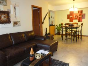 sala de estar con sofá de cuero marrón y mesa en Departamento Quito Histórico, en Quito
