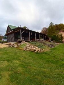 Chronowska chatka - zabytkowy dom z bali : منزل أمامه كومة من الصخور