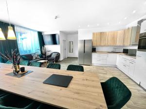 a kitchen and living room with a large wooden table at LeNi Living - Riesig! Repräsentativ! Ruhig! in Munich