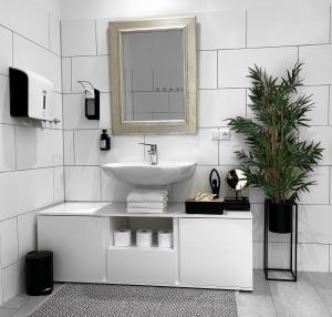 a white bathroom with a sink and a mirror at LeNi Living - Riesig! Repräsentativ! Ruhig! in Munich