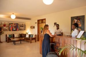 three women standing at a cash register in a salon at Karibu Entebbe in Entebbe