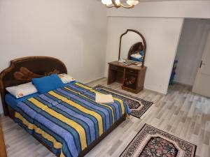 a bedroom with a bed and a mirror at TBK1 apartment in Alrehab city for families only in Burg el-Ḥudûd