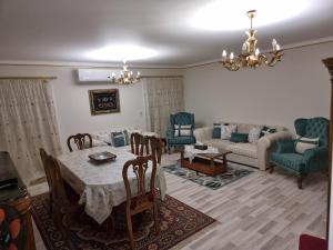 a living room with a table and chairs and a couch at TBK1 apartment in Alrehab city for families only in Burg el-Ḥudûd