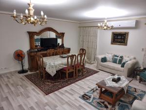 a living room with a table and a couch at TBK1 apartment in Alrehab city for families only in Burg el-Ḥudûd