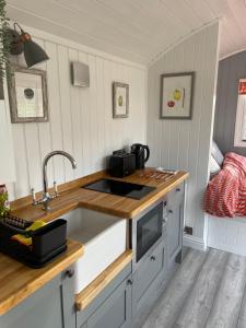 a kitchen with a sink and a counter at The Shepherd's Hut in Mixbury +12 photos