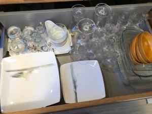 uma gaveta cheia de copos e pratos e uma tigela em GRIMAUD Vue piscine em Grimaud
