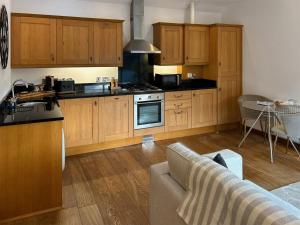 a kitchen with wooden cabinets and a living room at Oak in Falmouth