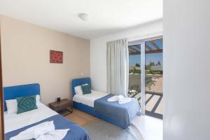 a bedroom with two beds and a balcony at Napa Sunlight Villa #1 in Ayia Napa