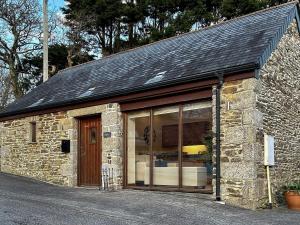 a small stone building with a large window at Oak in Falmouth