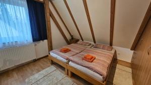 a bedroom with a bed with two orange pillows on it at Bei München Ferienwohnung Mahr in Kottgeisering "Mahr" in Kottgeisering