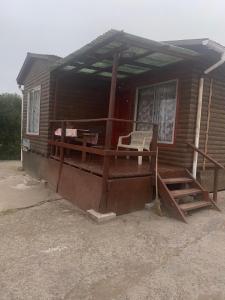 een huis met een veranda met een stoel erop bij Cabaña colmo in Quintero