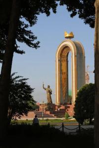 a statue in front of a building with a monument at Dom Shohon in Dushanbe