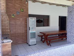 a patio with a wooden table and a refrigerator at Casa Em Pirangi Praia - RN in Parnamirim