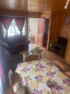 sala de estar con mesa y sofá en Cabaña colmo, en Quintero