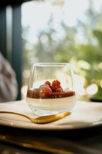 a bowl of strawberries on a plate with a spoon at Borralha Hotel, Restaurante & Spa in Vila Real