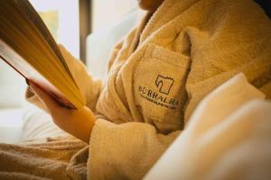 uma pessoa lendo um livro em um cobertor em Borralha Hotel, Restaurante & Spa em Vila Real
