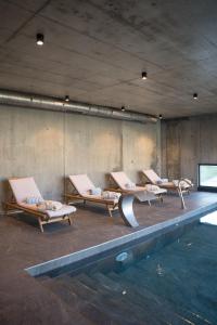 a group of lounge chairs next to a swimming pool at Borralha Hotel, Restaurante & Spa in Vila Real