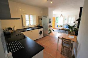 eine Küche mit einem Kühlschrank und einem Tisch sowie ein Esszimmer in der Unterkunft Casa del Cielo in Frigiliana