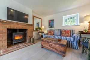 uma sala de estar com um sofá e uma lareira em The Long Cottage 4 em Flitcham
