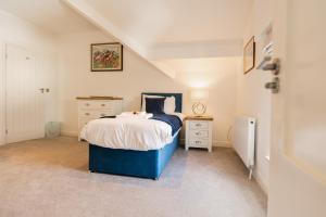 a bedroom with a blue bed and two night stands at Spacious & modern 2 bed flat in Hoylake - Opposite Royal Liverpool Golf Club in Hoylake