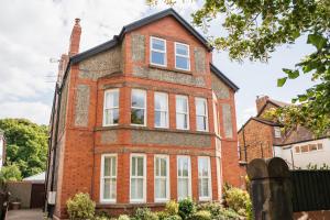 an old red brick house with white windows at Spacious & modern 2 bed flat in Hoylake - Near to Royal Liverpool Golf Club in Hoylake