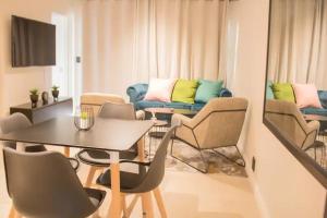 een woonkamer met een tafel en stoelen en een bank bij Lifestyle apartment in Sandton - Urban39 in Sandown