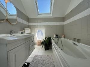 Coulaines的住宿－Havre de Vacances Piscine Reve au Mans，白色的浴室设有浴缸和水槽。