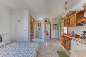 una camera con letto e una cucina con armadi in legno di Monolocale Margherita a Salve