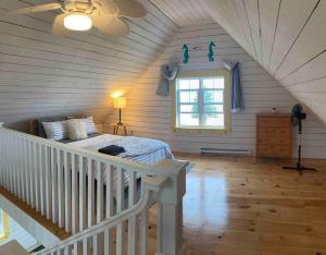 ein Schlafzimmer mit einem Bett im Dachgeschoss mit einem Fenster in der Unterkunft Sea Cliff Cottage in Edwardsville