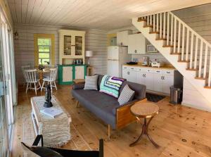 a living room with a couch and a kitchen at Sea Cliff Cottage in Edwardsville