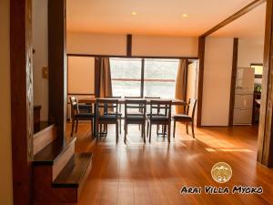 uma sala de jantar com mesa e cadeiras em Arai Villa Myoko em Myoko