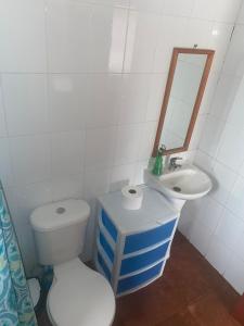 Baño blanco con aseo y lavamanos en Cabaña colmo, en Quintero