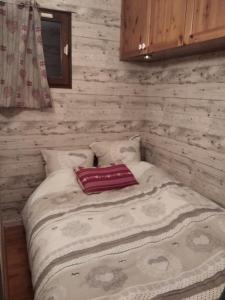 een klein bed in een kamer met houten wanden bij Le nid de Chamechaude in Saint-Pierre-de-Chartreuse