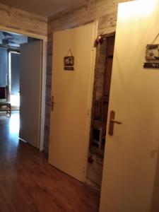 - un couloir avec deux portes et une chambre revêtue de parquet dans l'établissement Le nid de Chamechaude, à Saint-Pierre-de-Chartreuse