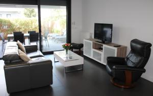 sala de estar con sillas negras y TV en Anglet/ Chambre d'amour-Chiberta -Plages & Golf, en Anglet