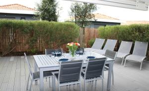 una mesa blanca y sillas en un patio en Anglet/ Chambre d'amour-Chiberta -Plages & Golf, en Anglet