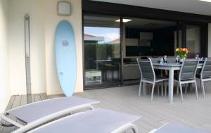 mesa y sillas con tabla de surf en el patio en Anglet/ Chambre d'amour-Chiberta -Plages & Golf, en Anglet
