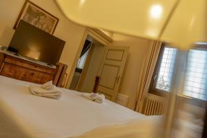 a bedroom with a bed with two towels on it at Il Castello Di San Gaudenzio in Cervesina