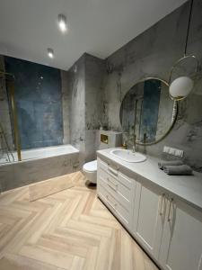 a bathroom with a sink and a toilet and a mirror at Apartament Vulcano Komfort Nowy Ursus in Warsaw