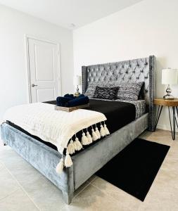 Beautiful Brand new 3bedroom home في بورت سانت لوسي: غرفة نوم مع سرير كبير مع اللوح الأمامي المعدني