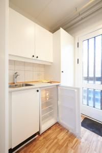 a kitchen with white cabinets and a sink and a window at Motel Apartments in Tønder
