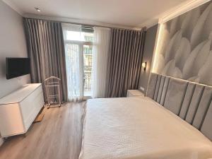 een slaapkamer met een groot bed en een raam bij LUXE PALAIS DE LA MÉDITERRANÉE in Nice