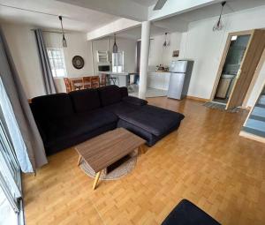 a living room with a black couch and a table at Emira Poolside 3 bedroom family villa in Bain Boeuf