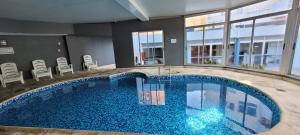 a large pool with blue water in a building at Punta Carretas, Garaje, Piscina, Gimnasio in Montevideo