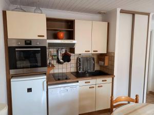 uma cozinha com armários brancos e um forno com placa de fogão em Saint Palais sur Mer - APPARTEMENT en RDC - proximité CENTRE et PLAGE em Saint-Palais-sur-Mer