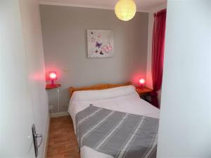 um pequeno quarto com uma cama e 2 candeeiros vermelhos em Saint Palais sur Mer - APPARTEMENT en RDC - proximité CENTRE et PLAGE em Saint-Palais-sur-Mer